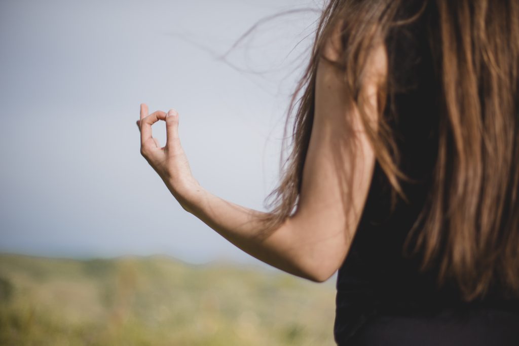 unrecognizable girl meditating nature
